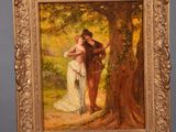 an oil painting of a couple kissing under a tree on a easel