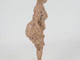 sculpture of a woman standing on a square base with her back to the camera