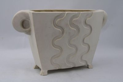 a white planter with a wavy design on it