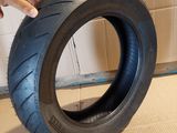 someone is holding a tire that is on the ground in front of a wall