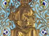 an image of a blue and gold plate with a gold statue on it