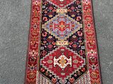 un tapis rouge et bleu sur un sol gris