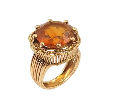 a close up of a ring with an orange stone on it
