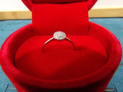 une boîte à bague en velours rouge contenant une bague en diamant