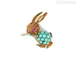 une image représentant une broche en forme de lapin ornée de pierres turquoise et roses