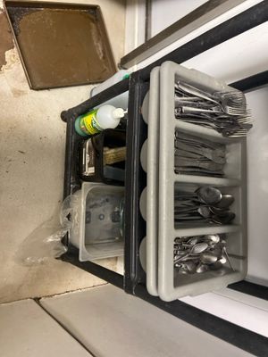 a small refrigerator with a lot of utensils inside of it