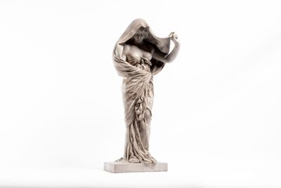 statue d'une femme tenant un oiseau sur fond blanc