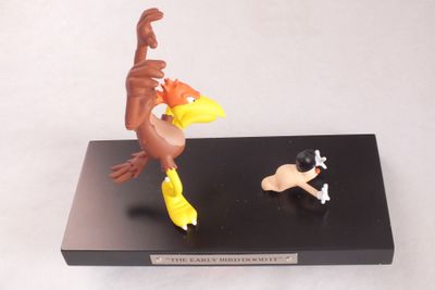 figurine représentant un oiseau et un chien, posée sur un socle noir
