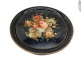une assiette noire ornée d'un motif floral