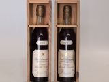 deux bouteilles de vin dans un coffret en bois sur une surface blanche