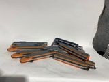 une pile d'agrafeuses orange et noires posées sur une surface blanche