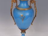 a blue vase with a gold decoration on it