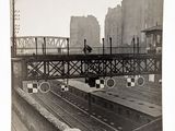 une photo en noir et blanc d'un train traversant un pont
