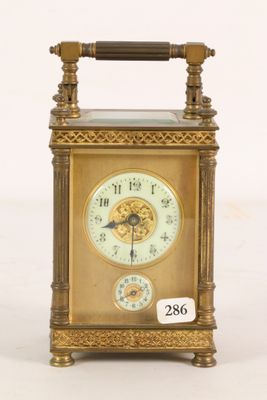 a gold clock that is sitting on a white surface