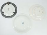 three white plates with black rims are sitting on a white surface