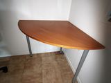 a corner desk with a wooden top and metal legs