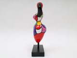 a multicolored sculpture of a woman on a black base