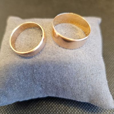 deux alliances posées sur un coussin, sur une table