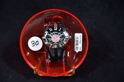 une montre dans un étui en plastique posé sur une surface noire