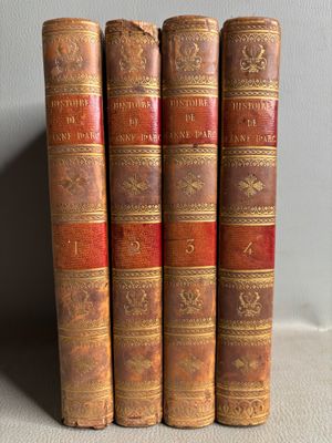 quatre vieux livres posés les uns à côté des autres sur une table blanche