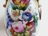 a vase with flowers painted on it sitting on a table