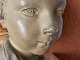 a statue of a boy that is sitting on a table