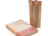several books are stacked on top of each other on a white surface