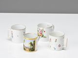 quatre tasses à café ornées de motifs floraux, posées sur une table