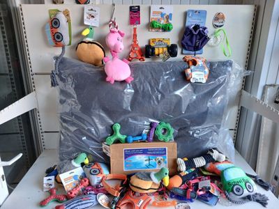 a pile of toys on a table in front of a refrigerator