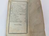 an old book with a piece of paper on it sitting on a table