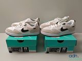 Deux paires de baskets blanches et noires sont posées sur une boîte.