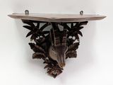 a bird that is sitting on a shelf on the wall