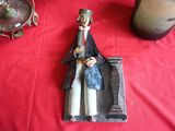 une figurine représentant un homme assis sur une table rouge