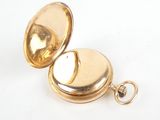 an image of a gold pocket watch on a white surface