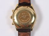 a gold watch with a brown leather band