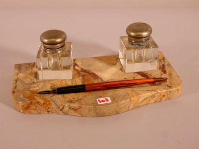 deux salières et poivrières et un stylo posés sur un caillou