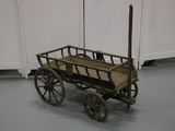 a small wooden wagon with a wooden seat on the floor