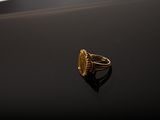 an image of a gold ring sitting on top of a black surface