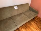 a couch with a price tag on it in the corner of a room