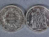 two silver coins, one of which is a woman and one of which is a man