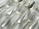 many forks and spoons wrapped in plastic bags