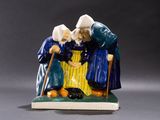 une figurine représentant deux personnes debout l'une à côté de l'autre