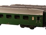 a green train car that is sitting on the tracks