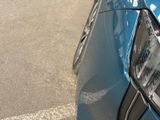 a close up of a blue car parked on the side of the road