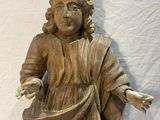 a wooden statue of a man holding a bag