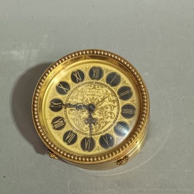 a gold clock with roman numerals on the face