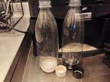 two empty bottles of water on the counter of a coffee shop
