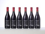 six bottles of red wine lined up in a row