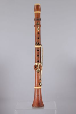 a close up of a wooden clarinet on a clear surface