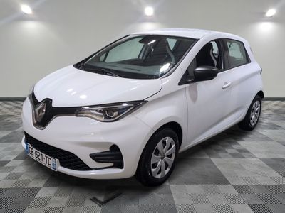 la voiture blanche est garée sur un sol en damier dans le garage